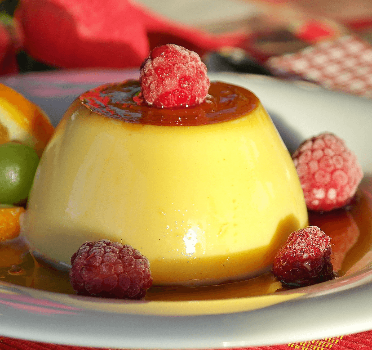 Puding sa karamel prelivom i malinama na tanjiru